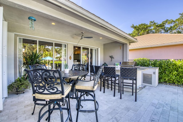 view of patio / terrace featuring ceiling fan, exterior kitchen, and an outdoor bar