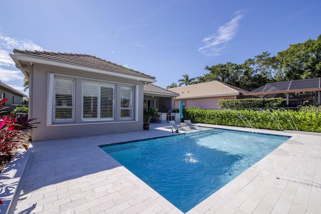 view of swimming pool with pool water feature and a patio