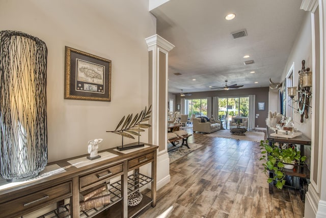 hall featuring wood-type flooring, a textured ceiling, and decorative columns