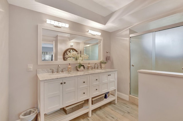 bathroom with walk in shower, wood-type flooring, and vanity