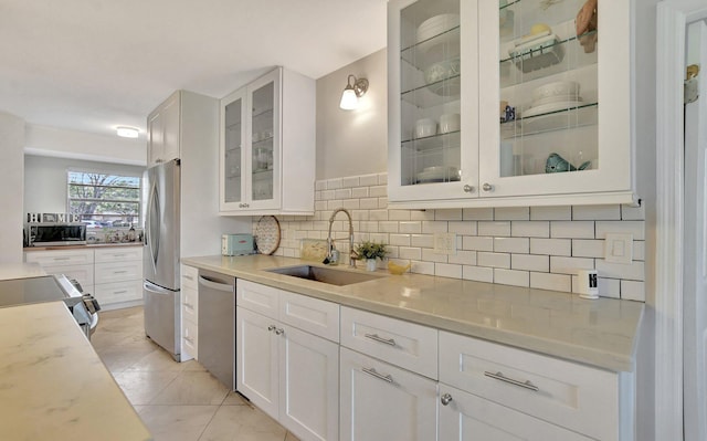 kitchen featuring light stone counters, stainless steel appliances, sink, and white cabinets