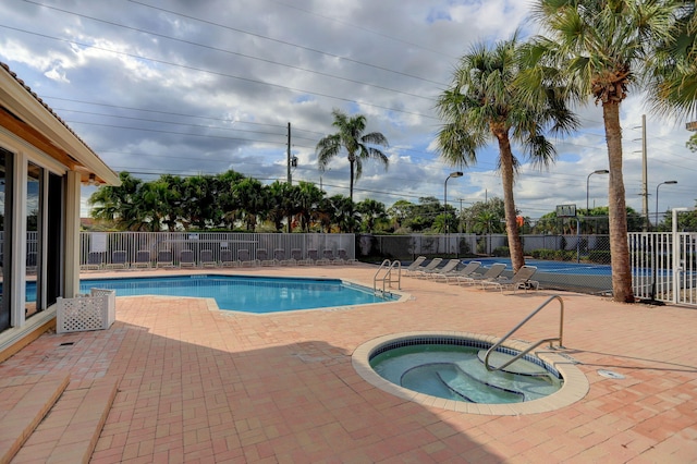 view of pool featuring a community hot tub and a patio area