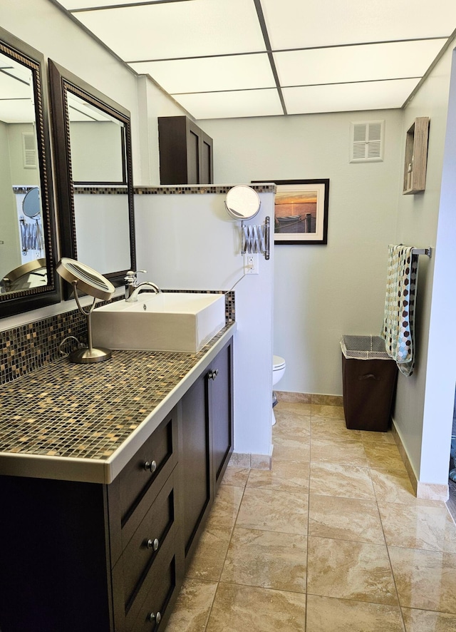 bathroom with vanity, a paneled ceiling, and toilet