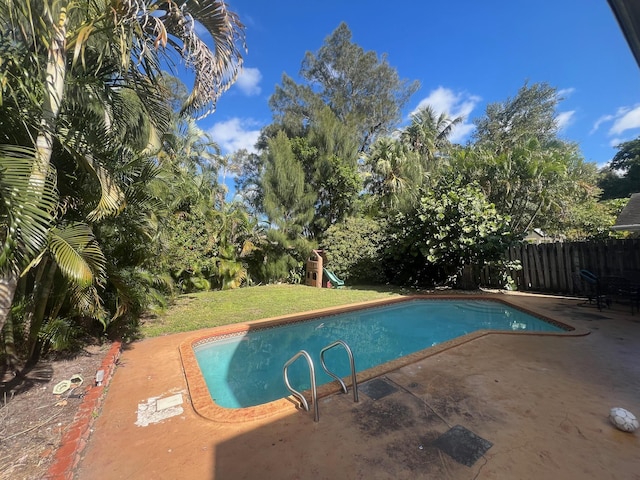 view of pool with a lawn and a patio