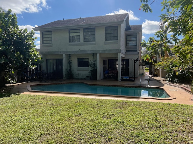 back of property with a yard and a patio