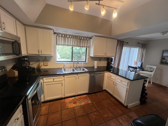 kitchen with pendant lighting, white cabinets, stainless steel appliances, sink, and kitchen peninsula