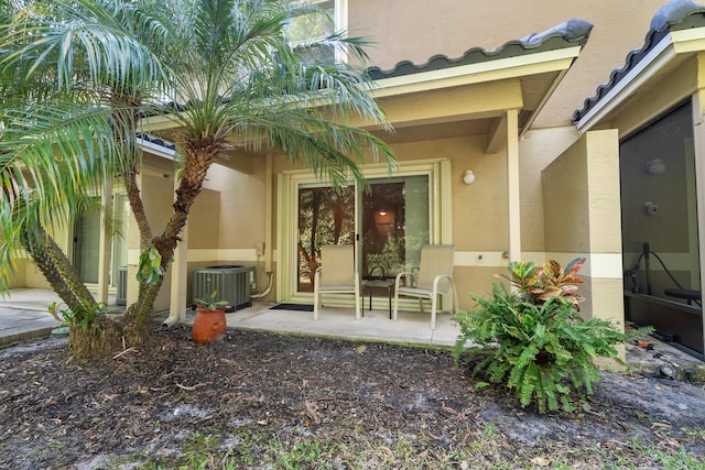 doorway to property featuring central AC unit and a patio area