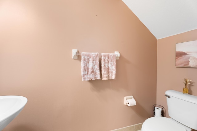 bathroom featuring toilet, lofted ceiling, and tile patterned floors