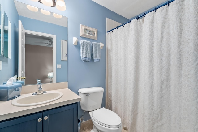 bathroom featuring toilet, vanity, and ceiling fan