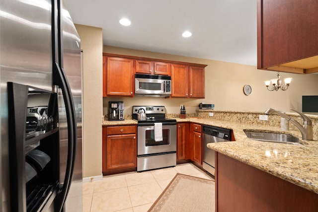 kitchen featuring light stone countertops, appliances with stainless steel finishes, an inviting chandelier, sink, and light tile patterned floors