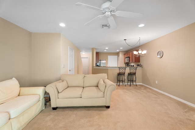 carpeted living room featuring ceiling fan with notable chandelier