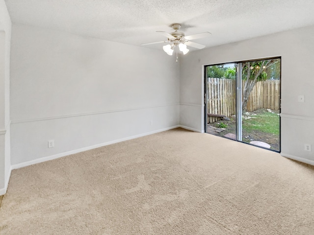 spare room featuring a textured ceiling, carpet floors, and ceiling fan