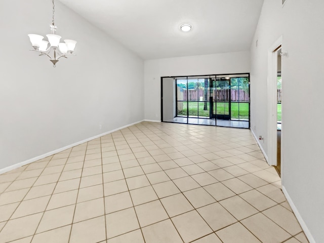 spare room featuring light tile patterned floors and a chandelier