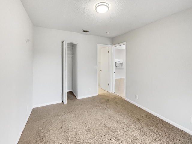 unfurnished bedroom with a closet, a textured ceiling, and carpet floors