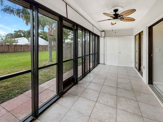 unfurnished sunroom featuring ceiling fan