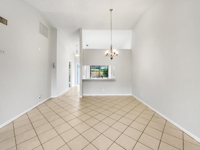 unfurnished living room featuring high vaulted ceiling, light tile patterned floors, and a chandelier