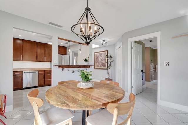 tiled dining space featuring an inviting chandelier