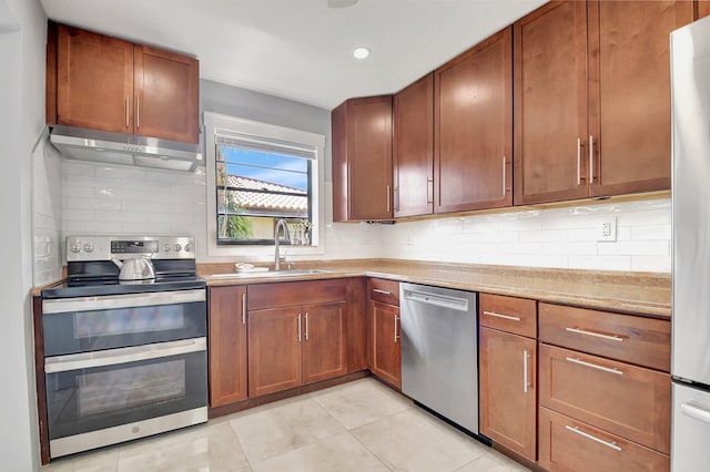 kitchen featuring sink, light tile patterned floors, tasteful backsplash, and appliances with stainless steel finishes