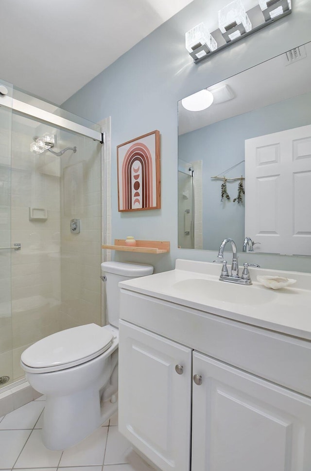 bathroom with a shower with door, vanity, tile patterned floors, and toilet