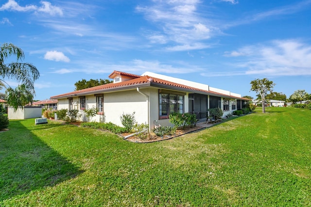 view of home's exterior featuring a lawn and a sunroom