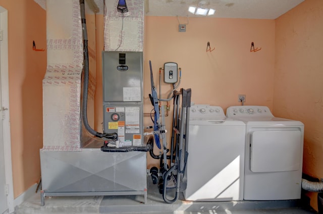 clothes washing area featuring washing machine and clothes dryer and a textured ceiling