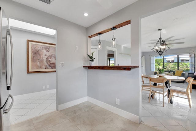 kitchen with stainless steel fridge, pendant lighting, and light tile patterned floors