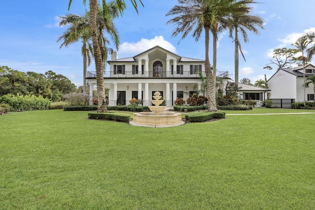 view of front facade featuring a balcony and a front lawn