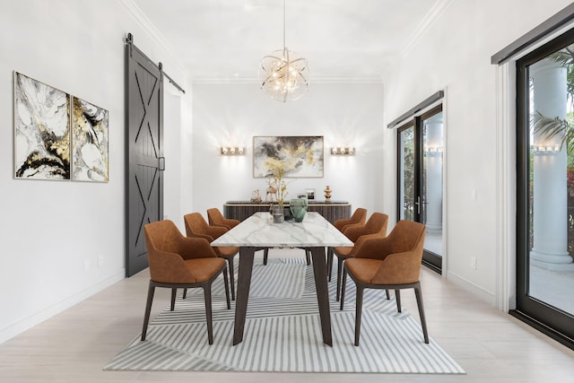 dining area with a chandelier, ornamental molding, and a barn door