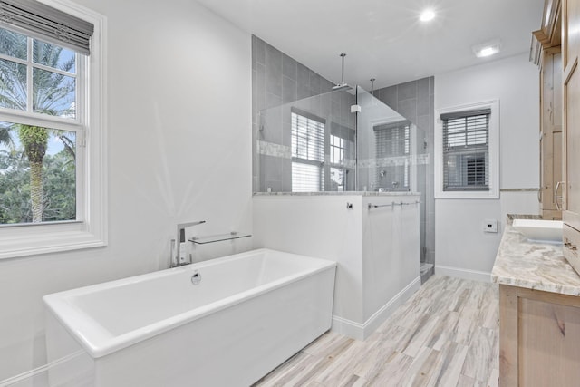 bathroom with vanity, wood-type flooring, and independent shower and bath