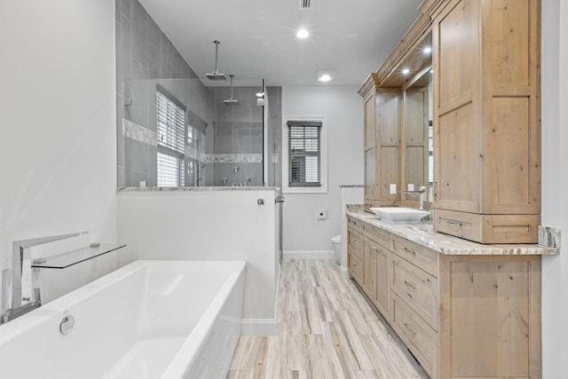 full bathroom with hardwood / wood-style floors, toilet, vanity, and independent shower and bath