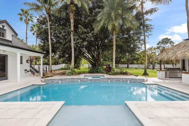 view of pool with an in ground hot tub, a patio, and area for grilling