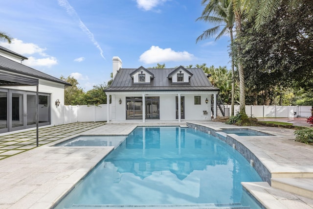 view of pool featuring an outbuilding, a patio area, and an in ground hot tub