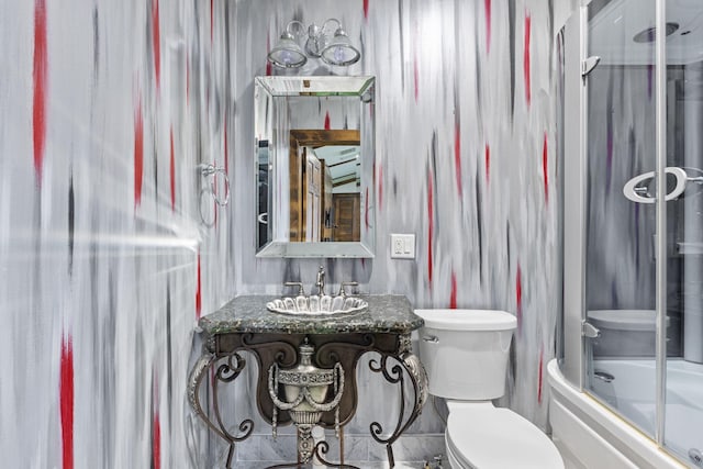 full bathroom featuring toilet, vanity, and shower / bath combination with glass door