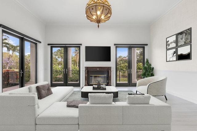 living room with hardwood / wood-style floors, a healthy amount of sunlight, ornamental molding, and french doors