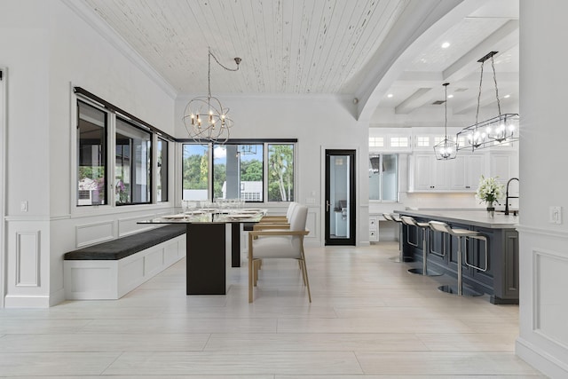 dining area with wood ceiling, coffered ceiling, ornamental molding, a chandelier, and beamed ceiling