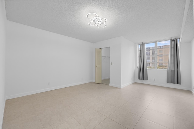 unfurnished bedroom featuring light tile patterned floors, a textured ceiling, and a closet