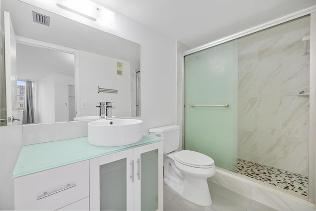 bathroom with tile patterned flooring, toilet, vanity, and walk in shower