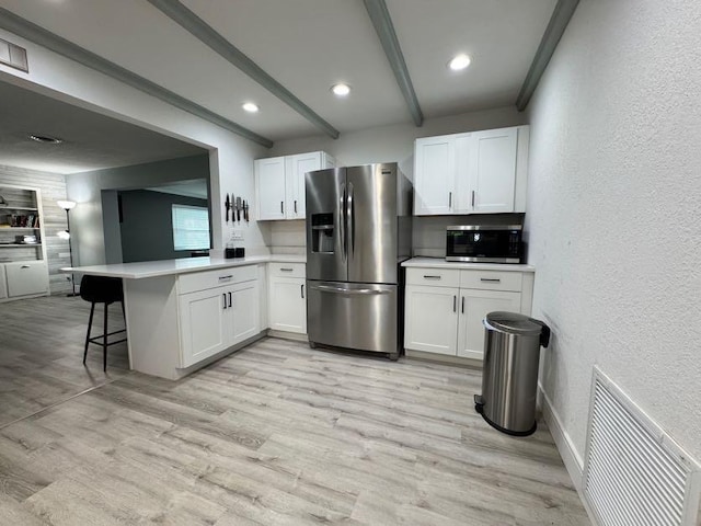 kitchen featuring white cabinetry, appliances with stainless steel finishes, and kitchen peninsula