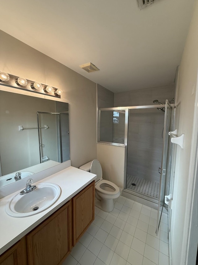 bathroom with tile patterned flooring, vanity, toilet, and a shower with door