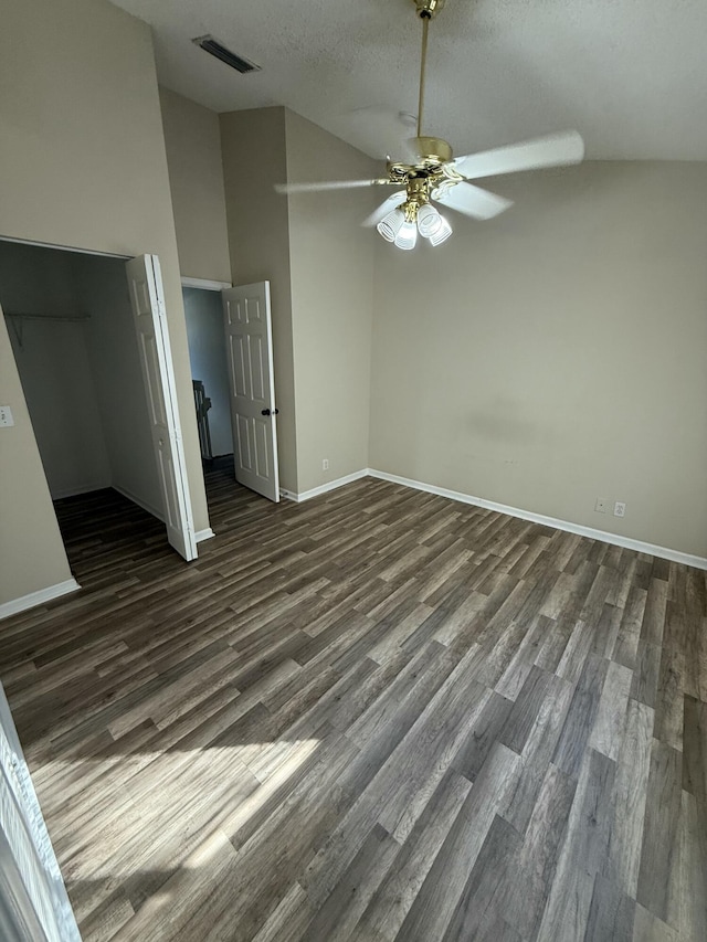 interior space with dark wood-type flooring, high vaulted ceiling, ceiling fan, a textured ceiling, and a closet