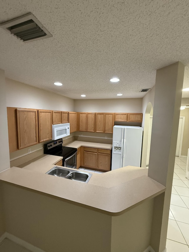 kitchen featuring sink, kitchen peninsula, a textured ceiling, white appliances, and light tile patterned floors