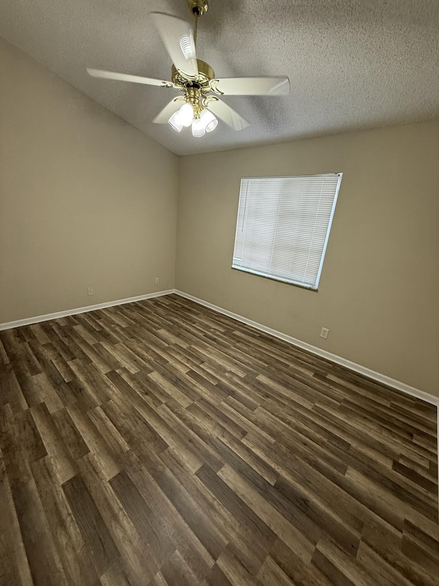 empty room featuring ceiling fan, a textured ceiling, and dark wood-type flooring