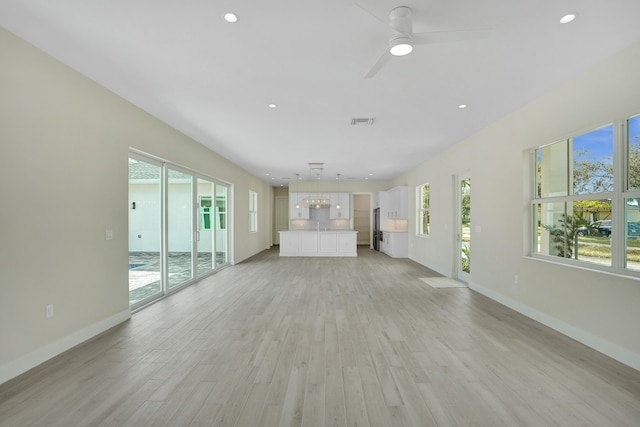 unfurnished living room featuring ceiling fan and light hardwood / wood-style floors