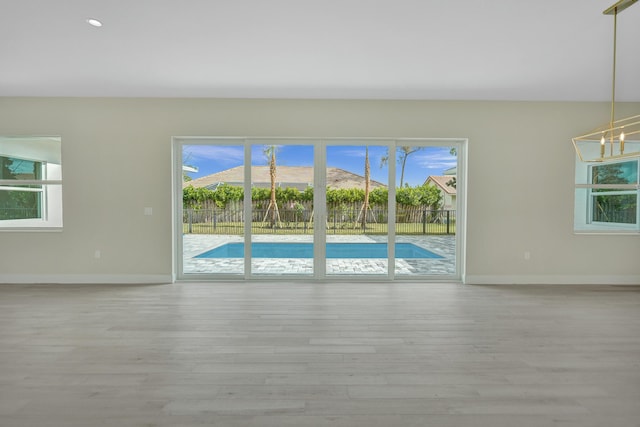 spare room with a mountain view, light hardwood / wood-style flooring, and a notable chandelier