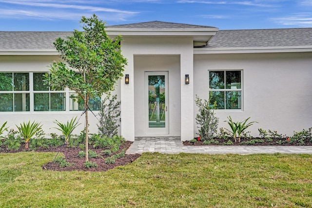 doorway to property featuring a lawn