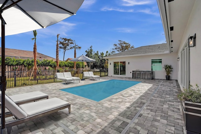 view of pool featuring a bar and a patio