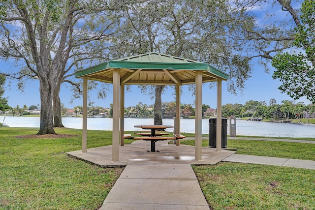 surrounding community with a gazebo, a water view, and a lawn