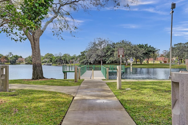 dock area with a water view and a lawn