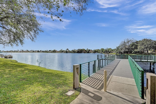 dock area with a water view and a lawn