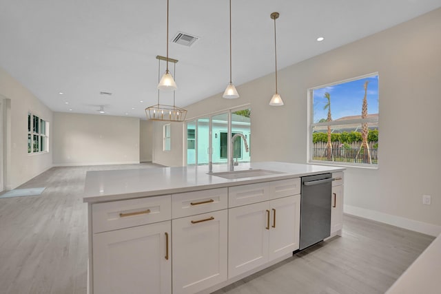 kitchen featuring white cabinets, decorative light fixtures, sink, stainless steel dishwasher, and a center island with sink